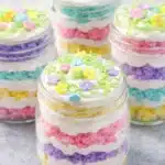 Easter cake in a jar with pastel layers and white frosting in glass jars