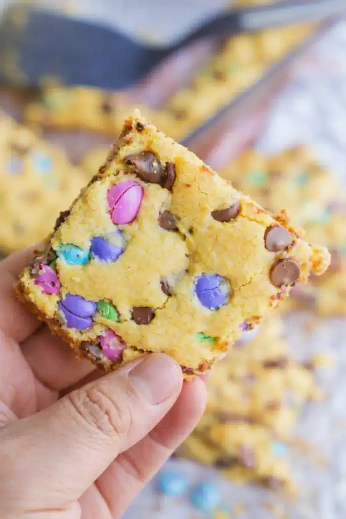 Easter Cake Mix Cookie Bars – Simple, Chewy, and Delicious 8 Man holding chewy Easter cake mix cookie bar with pastel M&Ms