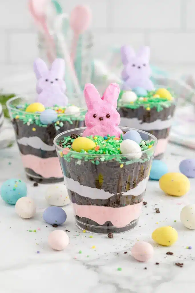 Easter Dirt Cups layered with pudding, Oreos, and topped with Peeps and candy eggs