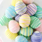 Pastel Easter Egg Oreo Cookie Balls on a white plate with colorful candy drizzle