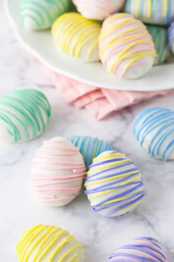 Easter Egg Oreo Cookie Balls – Easy, Fun & Delicious 6 Pastel Easter Egg Oreo Cookie Balls on marble with candy drizzle