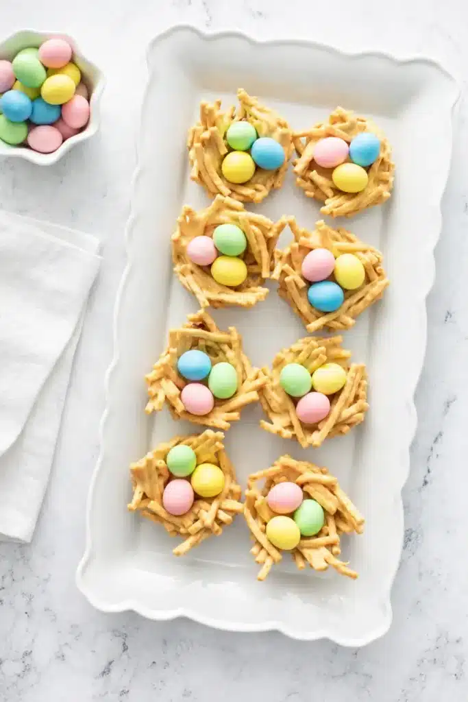 Easter Egg Peanut Butter Haystacks | Easy & Delicious Treat 9 Easter Egg Peanut Butter Haystacks served on white tray with pastel candy eggs