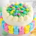 Easter Peep Cake with buttercream frosting, green coconut grass, and pastel candy eggs