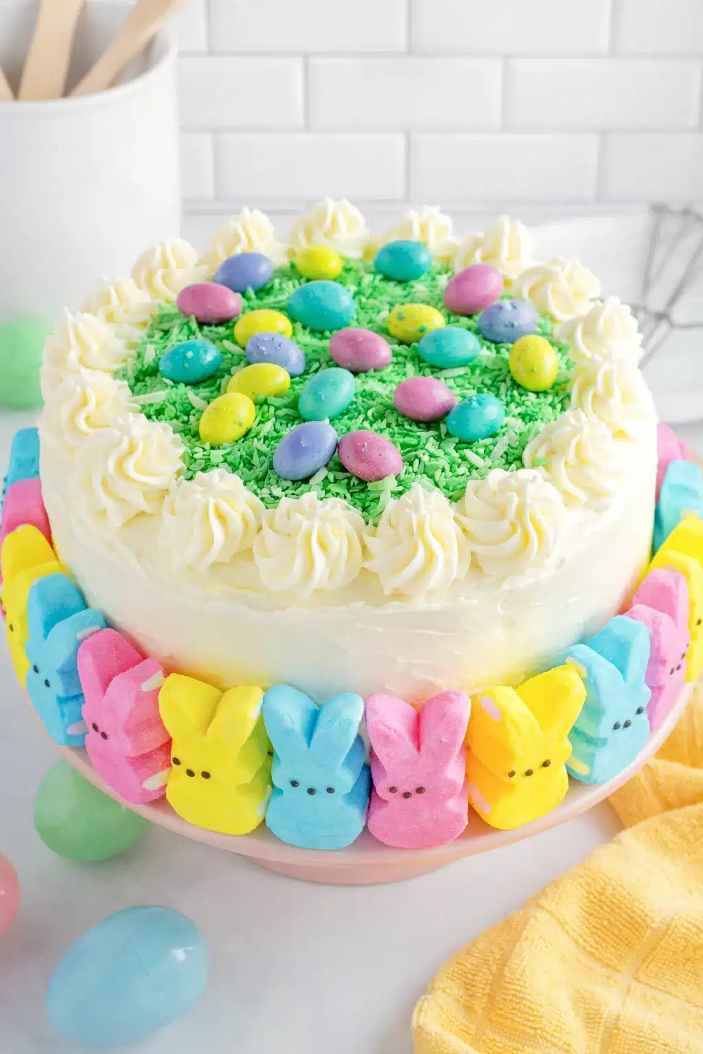 Easter Peep Cake with buttercream frosting, green coconut grass, and pastel candy eggs