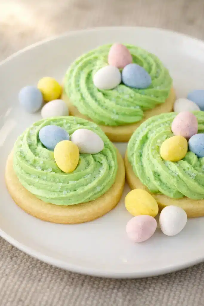 Easter sugar cookies with green frosting nests and pastel candy eggs