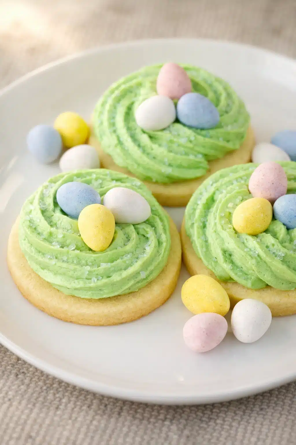 Easter sugar cookies with green frosting nests and pastel candy eggs