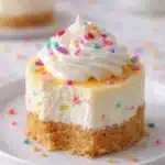 Easy Mini Birthday Cheesecakes topped with whipped cream and rainbow sprinkles