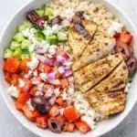 Greek chicken bowl with quinoa, grilled chicken, fresh vegetables, and feta cheese