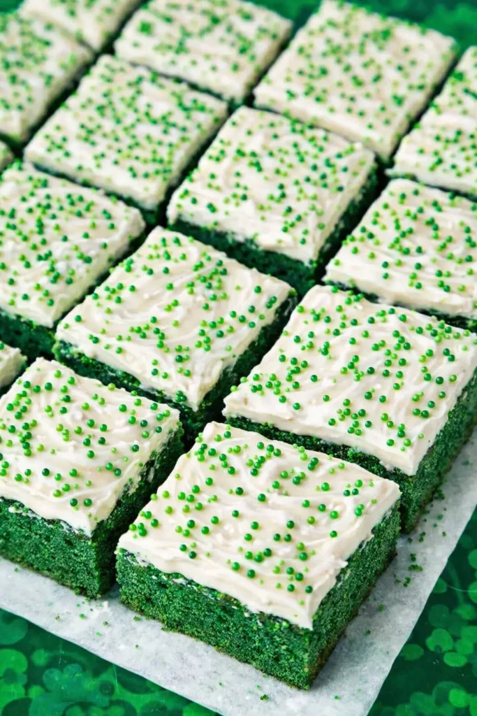 Green Velvet Brownies cut into squares with cream cheese frosting and green sprinkles