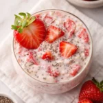 Healthy strawberry protein overnight oats with chia seeds and fresh strawberries in a glass