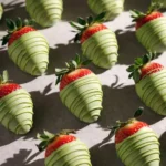 Matcha covered strawberries with green chocolate drizzle in natural sunlight