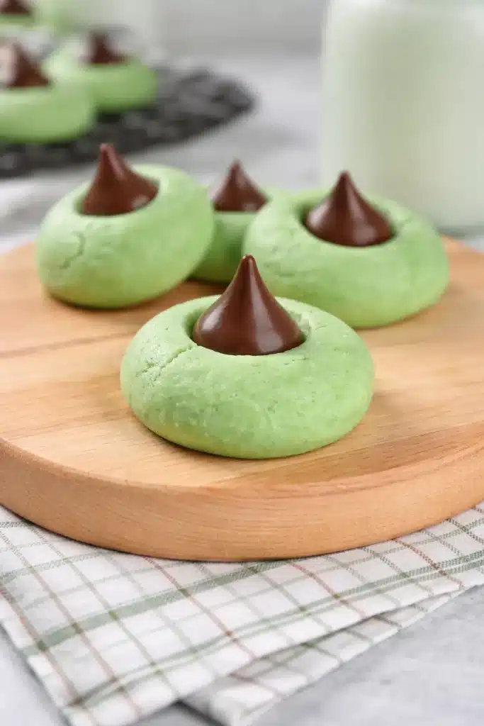 Mint Chocolate Kiss Blossom Cookies on wooden board with glossy chocolate tops