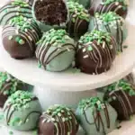 Mint Oreo balls on ceramic stand with chocolate drizzle and green sprinkles