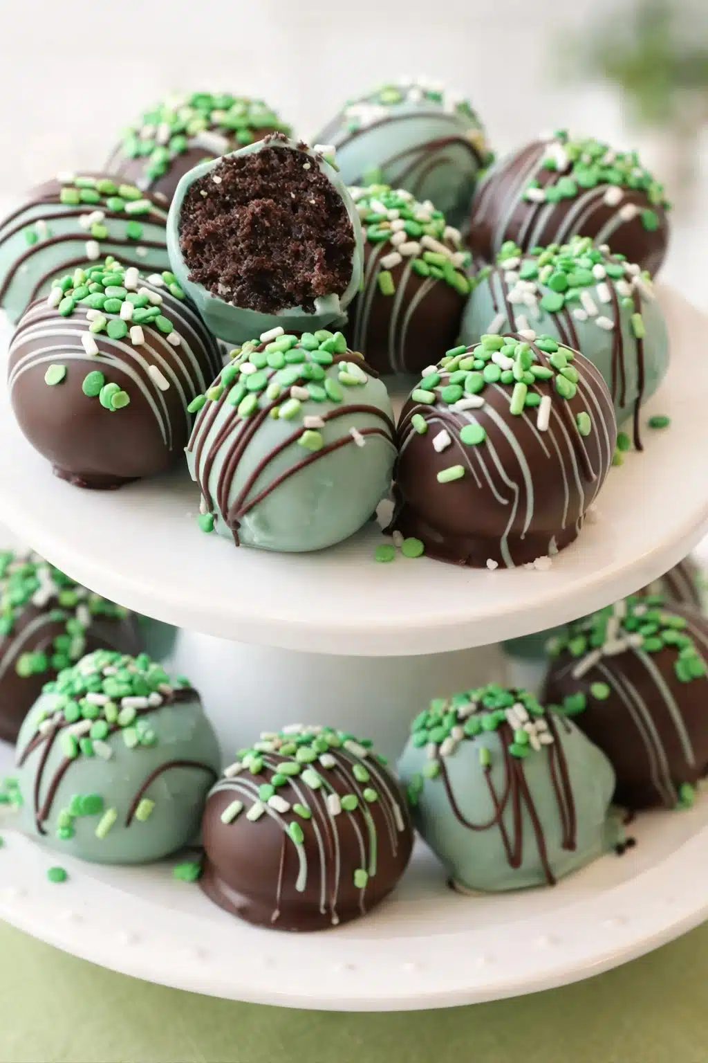Mint Oreo balls on ceramic stand with chocolate drizzle and green sprinkles