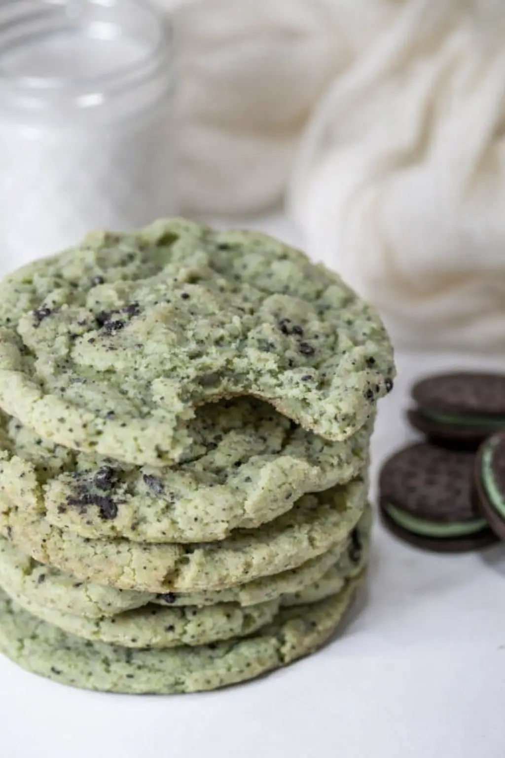 Stack of mint Oreo cookies with chocolate crumbs and soft chewy centers