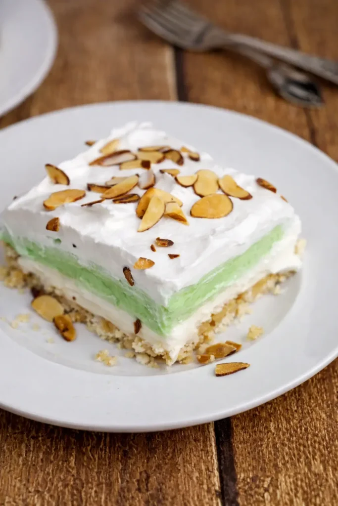 Pistachio Lush layered dessert slice with whipped topping and almonds