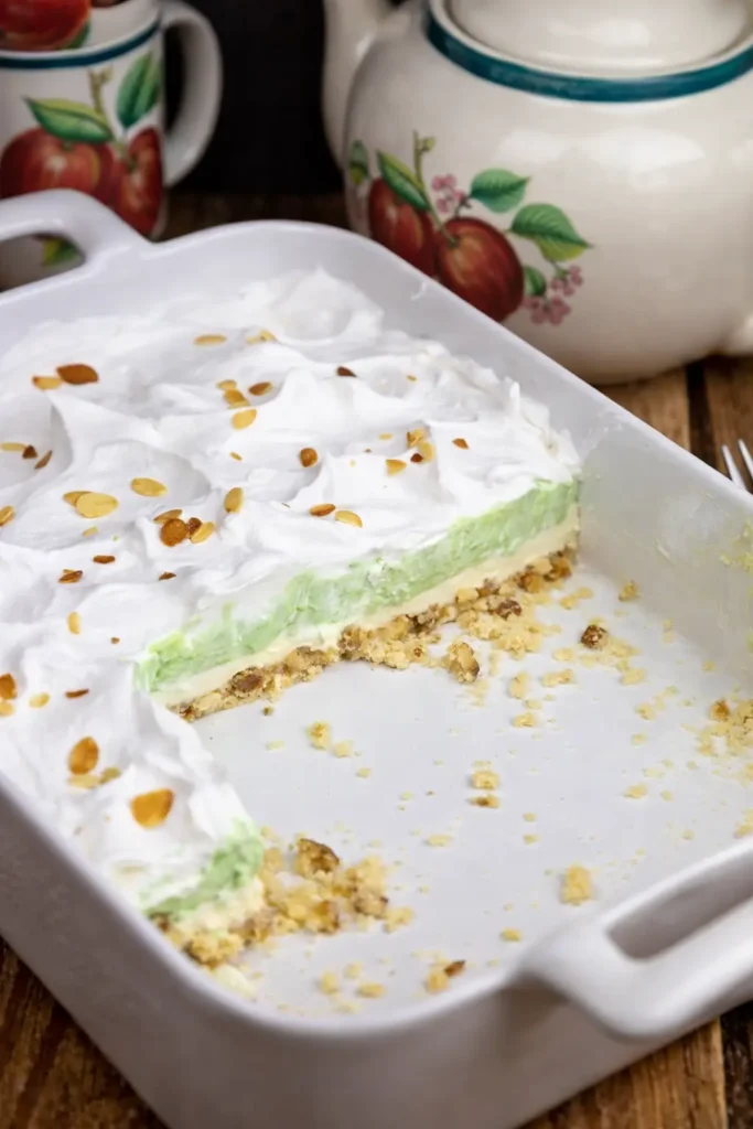 Pistachio Lush in baking dish with layered green pudding and whipped topping