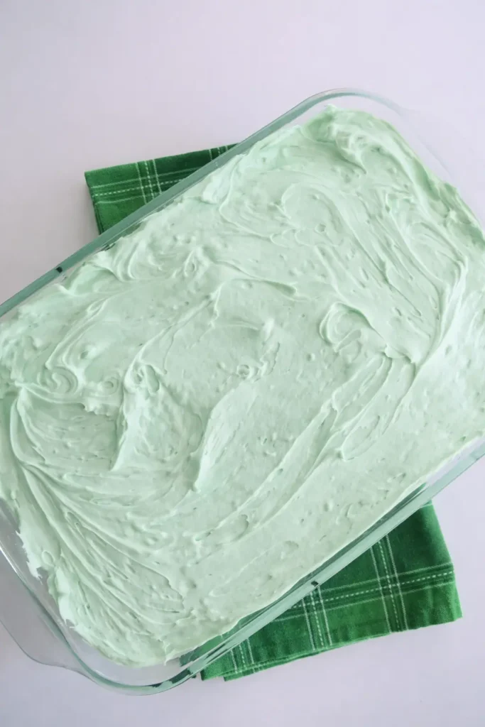 Pistachio Pudding Cake in glass baking dish with smooth mint frosting