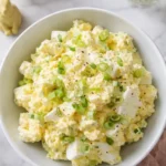 Creamy quick Easter egg salad topped with green onions in a pastel bowl