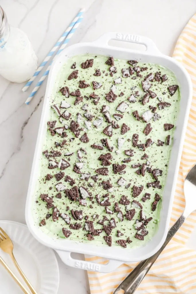 Shamrock Lasagna in white baking dish topped with crushed Oreos