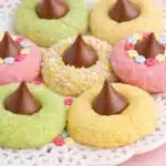 Pastel spring blossom cookies with chocolate kiss centers on ceramic platter