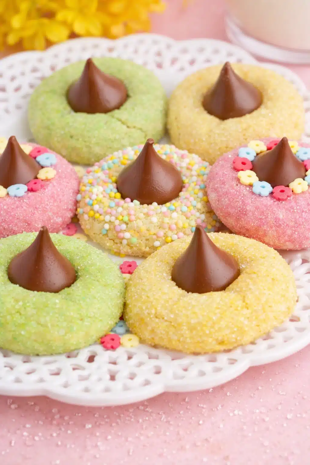 Pastel spring blossom cookies with chocolate kiss centers on ceramic platter