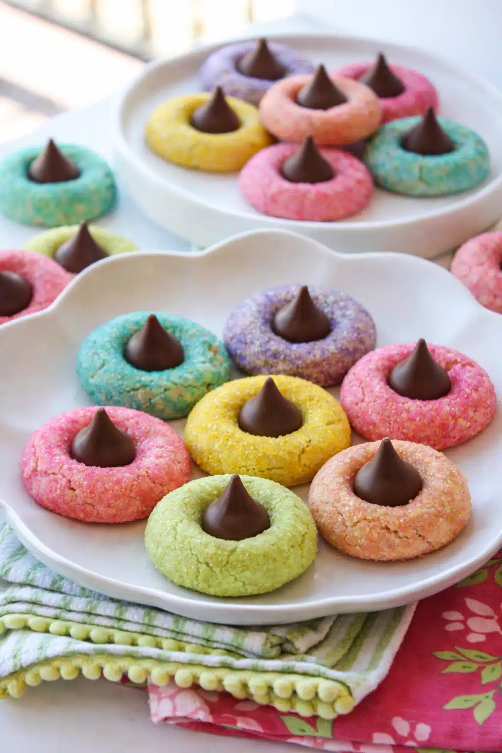 Colorful spring blossom cookies with chocolate centers on white plates
