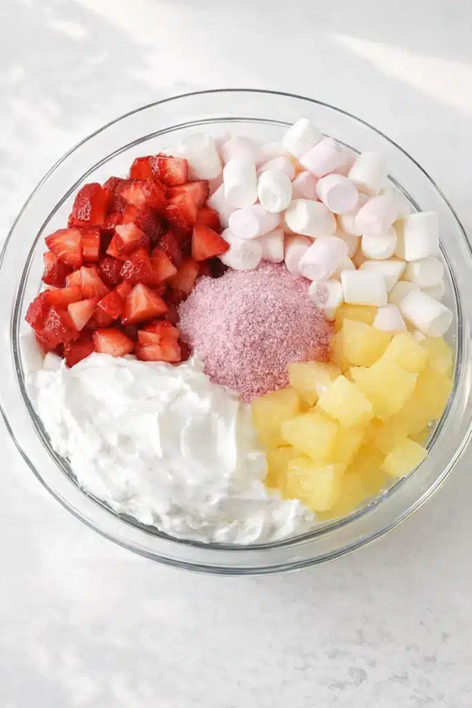 Strawberry fluff salad ingredients in a glass bowl ready to mix