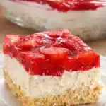 Slice of Strawberry Heaven Cake with cream and strawberry glaze on white plate