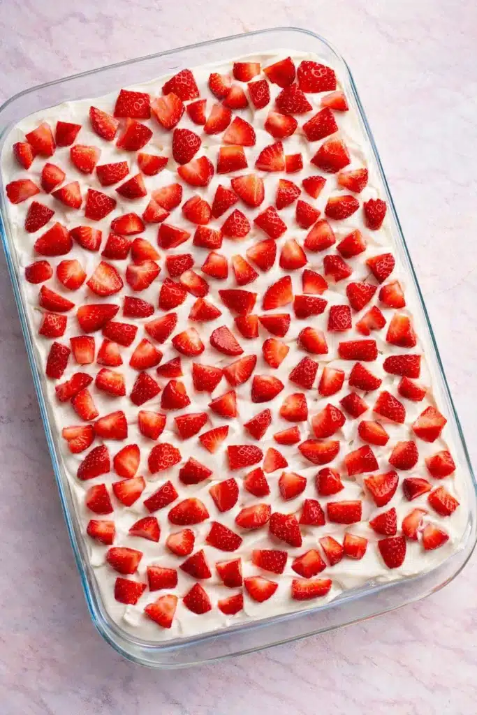 Strawberry Icebox Cake | Simple & Delicious No-Bake Treat 7 Strawberry icebox cake topped with fresh diced strawberries in a glass dish