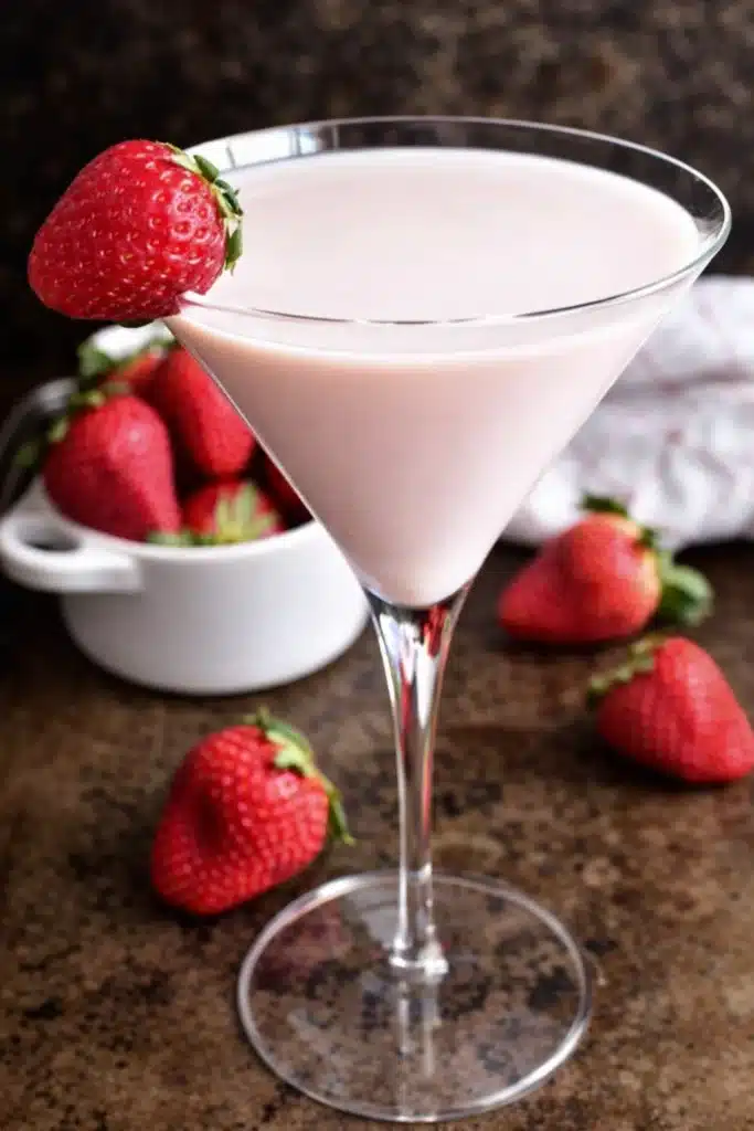 Creamy strawberry shortcake martini with fresh strawberries on rustic table