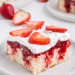 Strawberry Shortcake Poke Cake slice with whipped cream and fresh strawberries