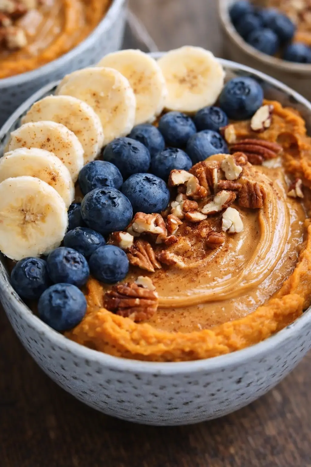 Sweet potato breakfast bowls with almond butter, bananas, blueberries and pecans