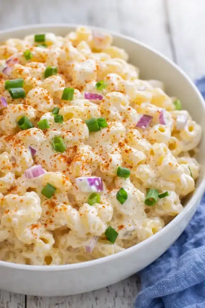 Tasty Deviled Eggs Pasta Salad | Easy Creamy Dinner 6 Creamy Tasty Deviled Eggs Pasta Salad with paprika and onions in white bowl