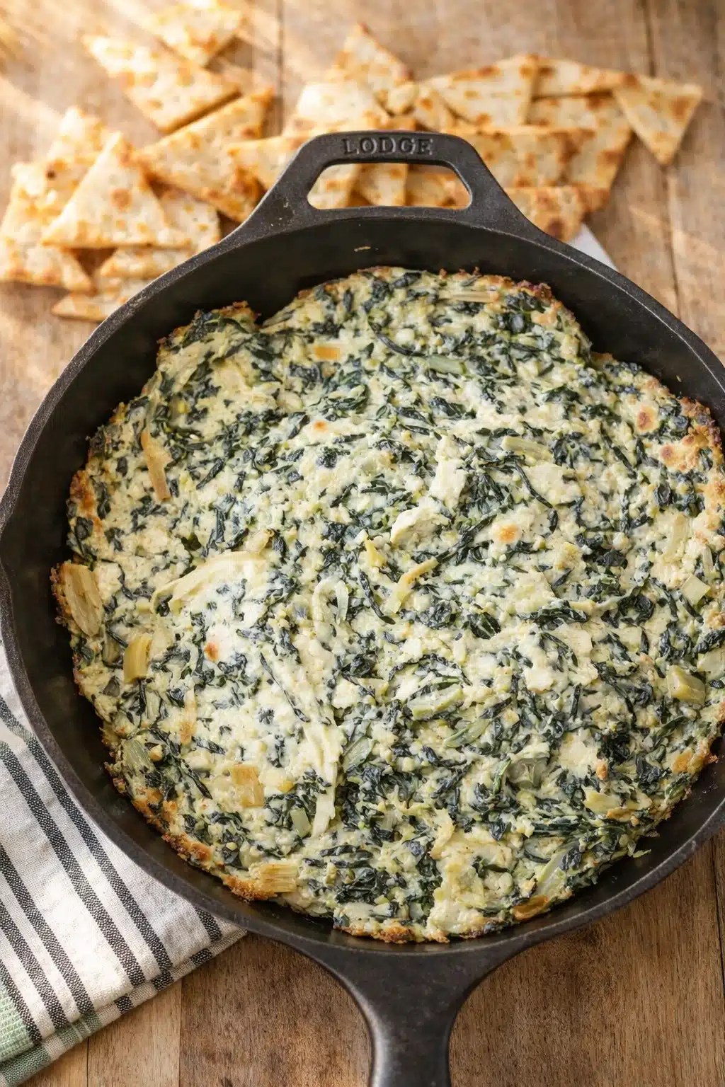 home 13 Creamy spinach artichoke dip in skillet with pita chips on wooden board