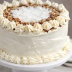 To Die For Carrot Cake with cream cheese frosting and pecans on a cake stand