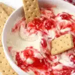 Strawberry cheesecake dip with graham crackers in white bowl
