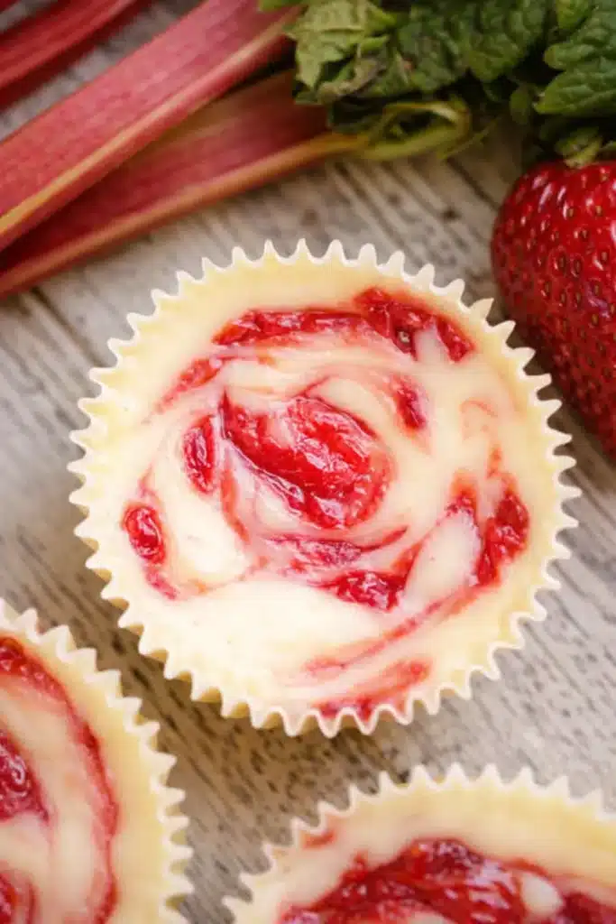 Strawberry Rhubarb Mini Cheesecakes with creamy filling and fruit swirl