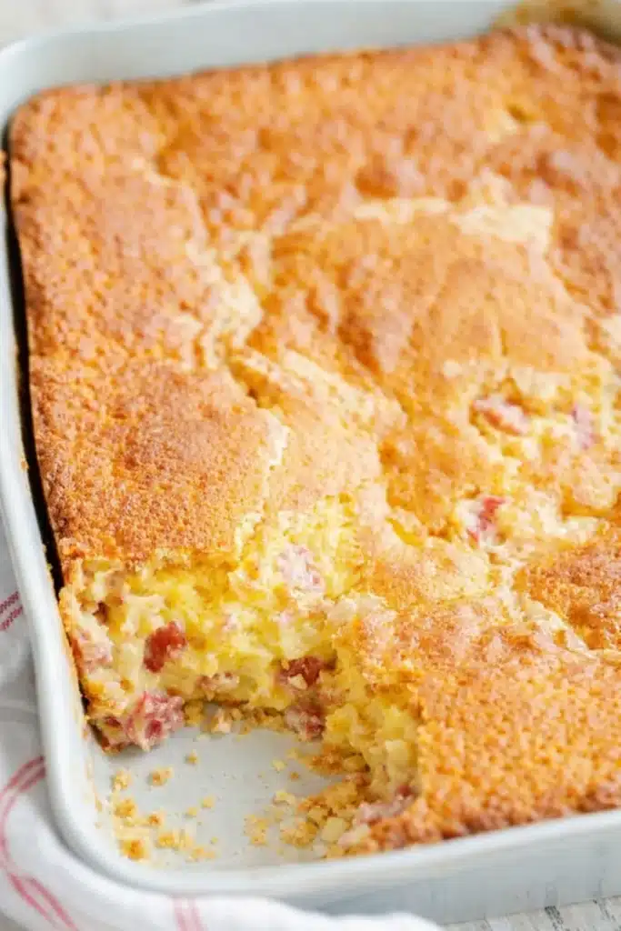Easy Rhubarb Custard Cake baked in a ceramic dish with creamy rhubarb filling