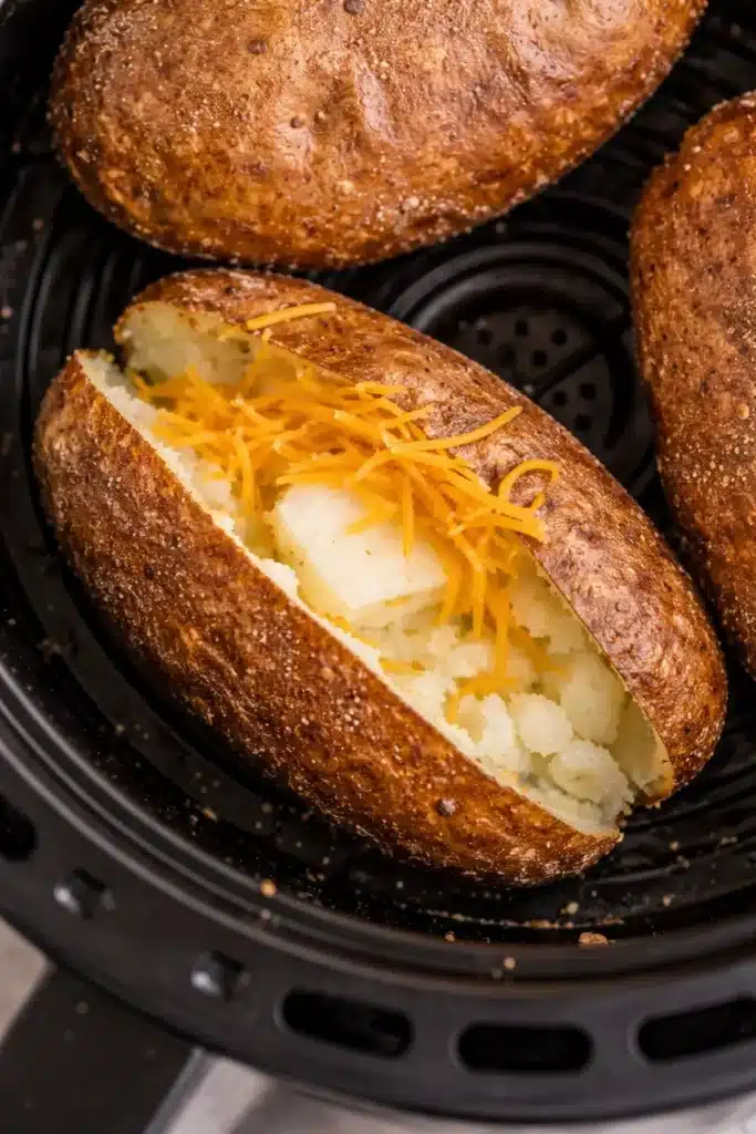Air fryer baked potato with crispy skin and fluffy inside topped with melting butter