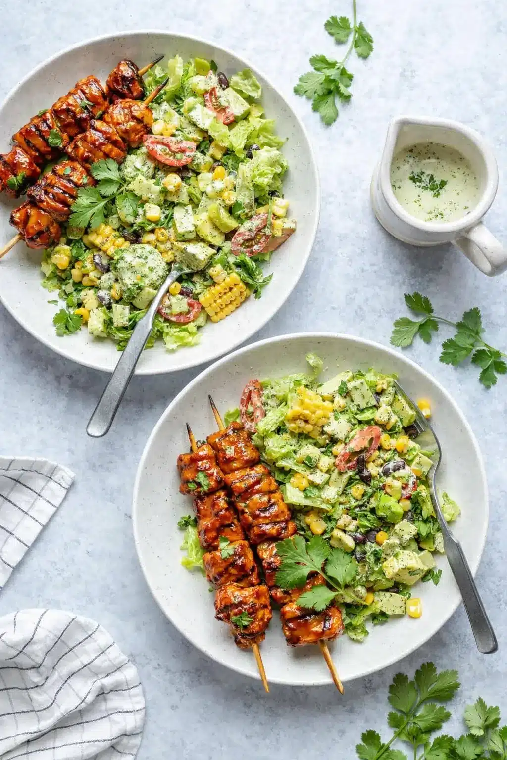 BBQ chicken skewer salad with grilled corn, avocado, tomatoes, and creamy herb dressing