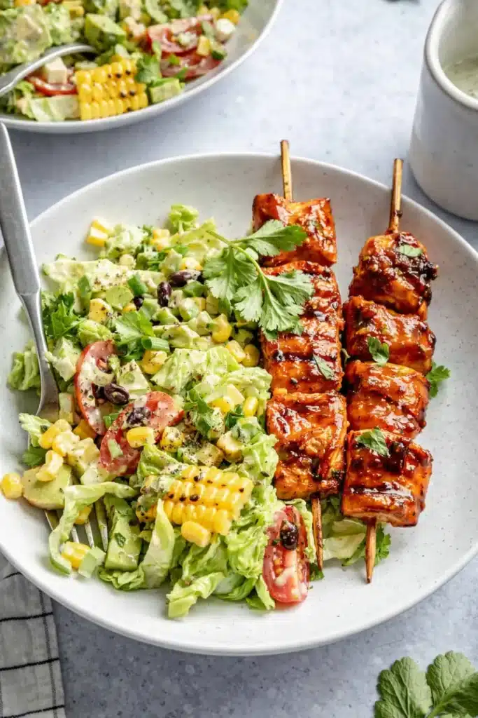 BBQ chicken skewer salad with grilled corn avocado and creamy herb dressing