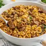 Beef tips and egg noodles in savory gravy served in a skillet