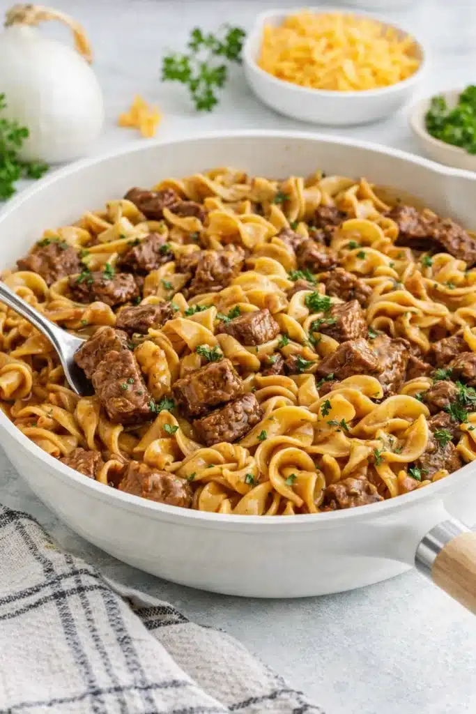 Beef tips and egg noodles in savory gravy served in a skillet