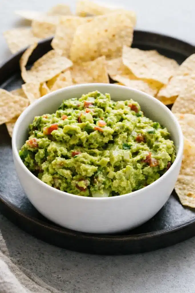 best guacamole recipe served in a bowl with crispy tortilla chips