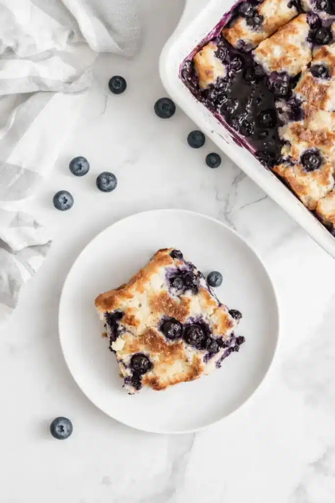 blueberry french toast casserole slice with baked blueberries on a white plate