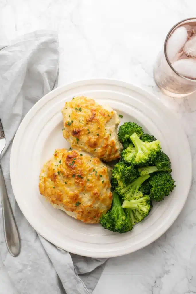 Cheddar ranch chicken thighs with broccoli on white plate