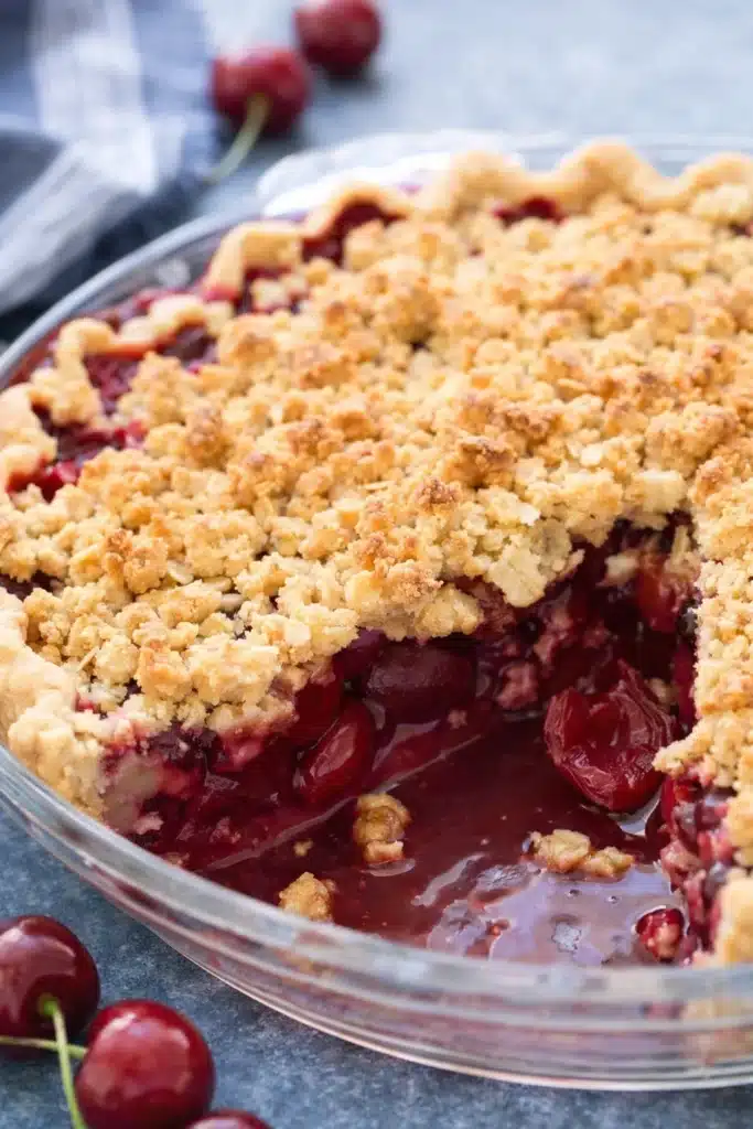 Cherry crumble pie with oat topping and juicy cherry filling in glass pie dish
