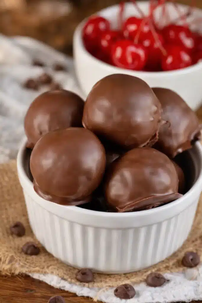 Chocolate covered cherry brownie bombs in a ramekin with smooth chocolate coating