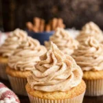 Churro cupcakes with cinnamon frosting and cinnamon sugar on a rustic surface